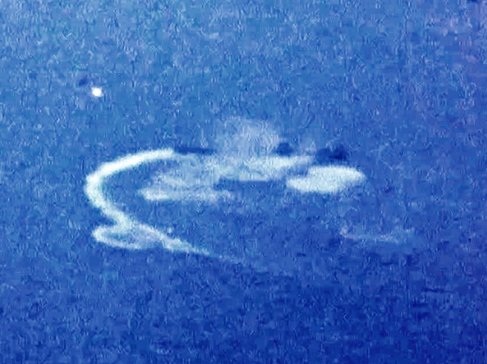 米軍の空襲を受け、右旋回しながら航行する戦艦「大和」。艦影が航跡の先に黒っぽく映っている（１９４５年３月１９日撮影）＝豊の国宇佐市塾提供