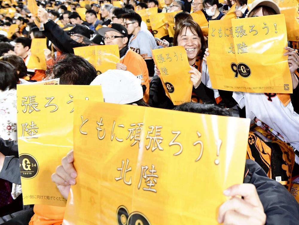 北陸応援メッセージのボードを掲げるファンら（１４日、富山市民球場で）＝細野登撮影