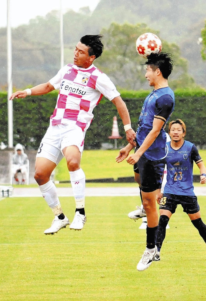 雨の中、激しい試合を繰り広げる選手たち