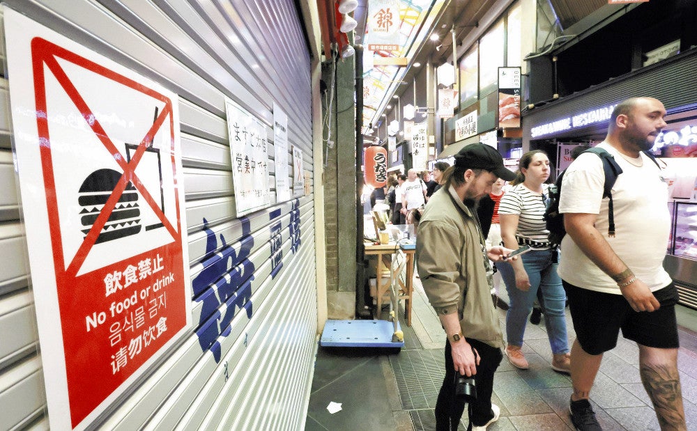 ピクトグラムを使って飲食禁止を呼びかける注意書き（１４日、京都市中京区の錦市場で）＝川崎公太撮影