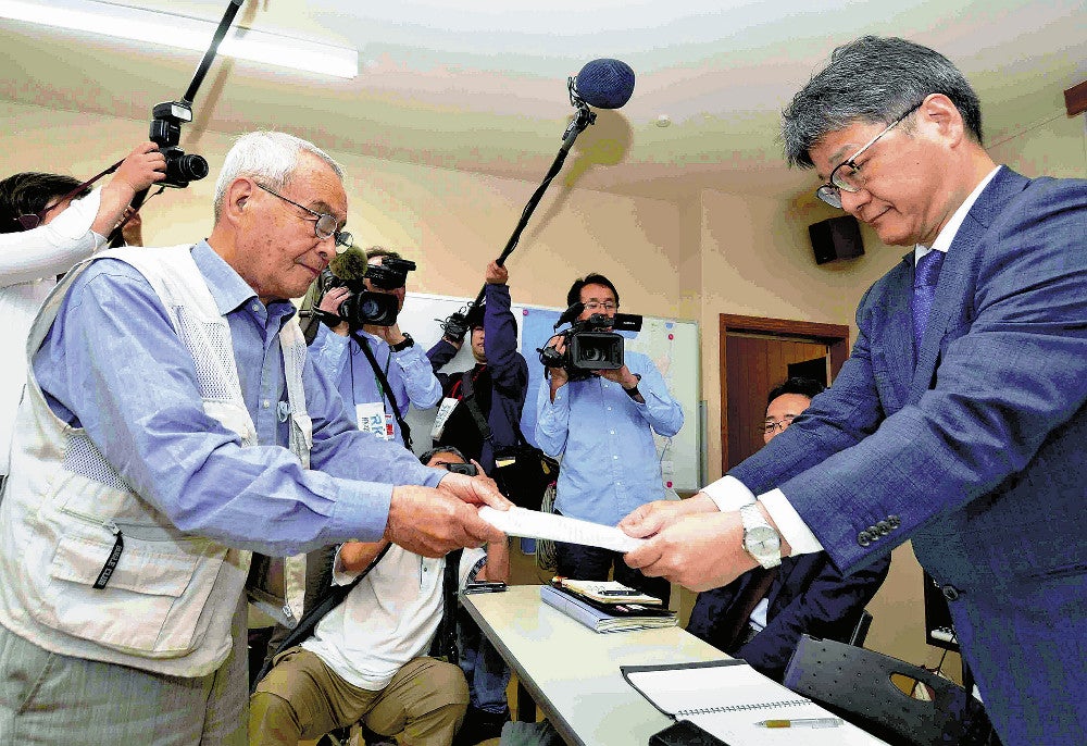 前田審議官（右）に要請書を手渡す山下代表（１６日午後０時１８分、熊本県水俣市で）＝白石一弘撮影