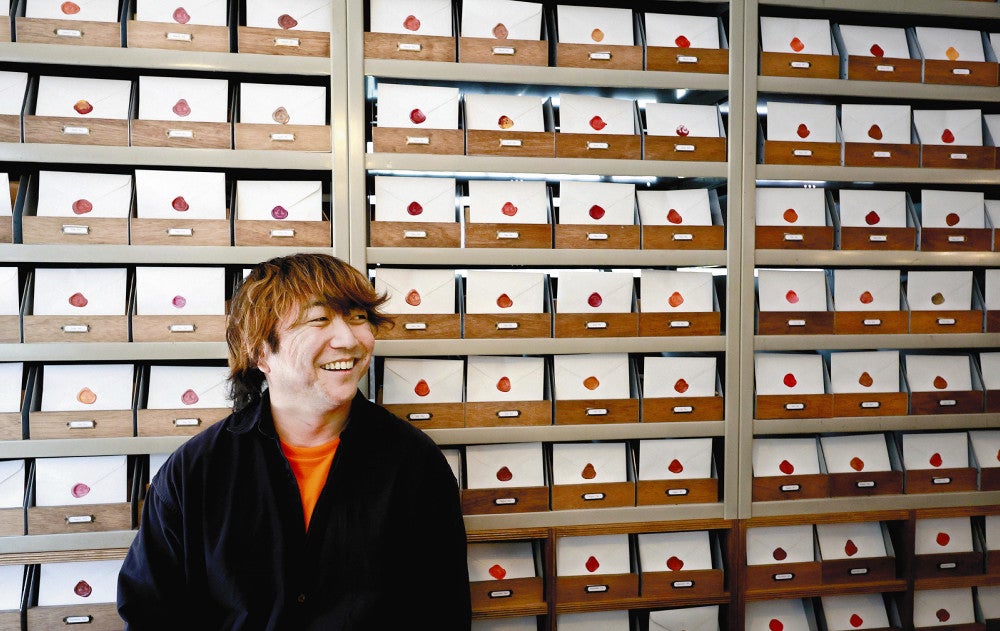 しっかりと封がされ、近くの２号店「封灯」で保管される手紙の前でほほえむ、オーナーで詩人の小山さん