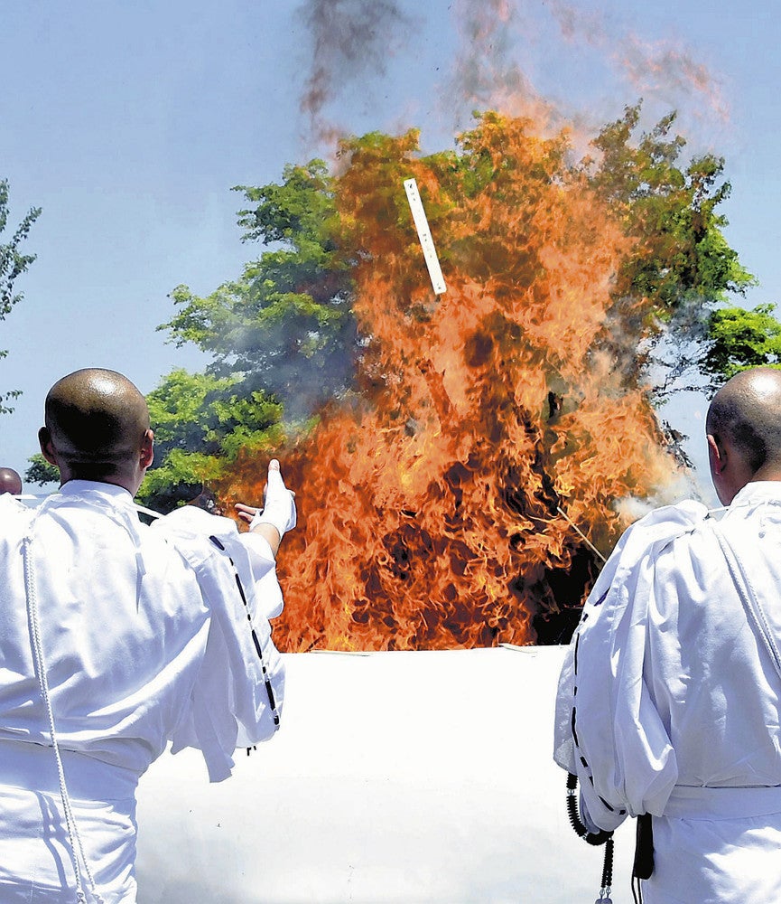 願いが記された護摩木が、立ち上る炎に向け次々に投じられた（大津市で）