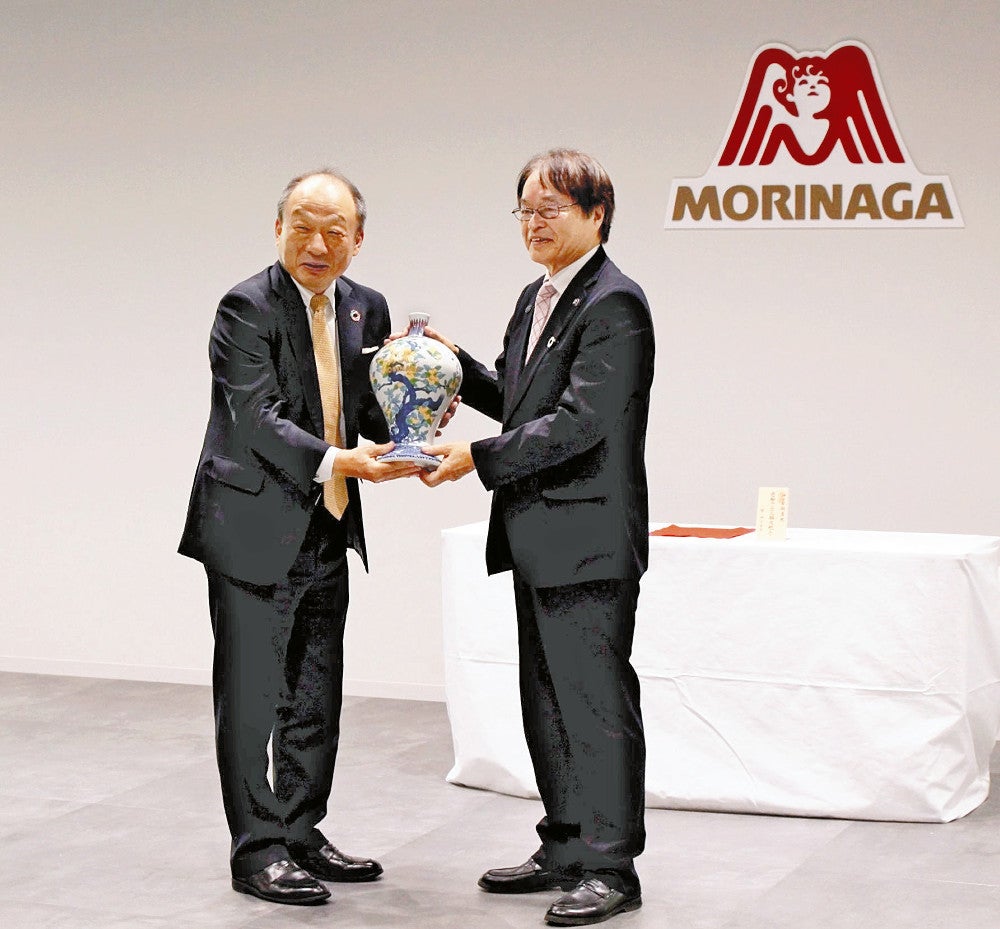 瓶子を受け取る太田社長（左）＝森永製菓提供