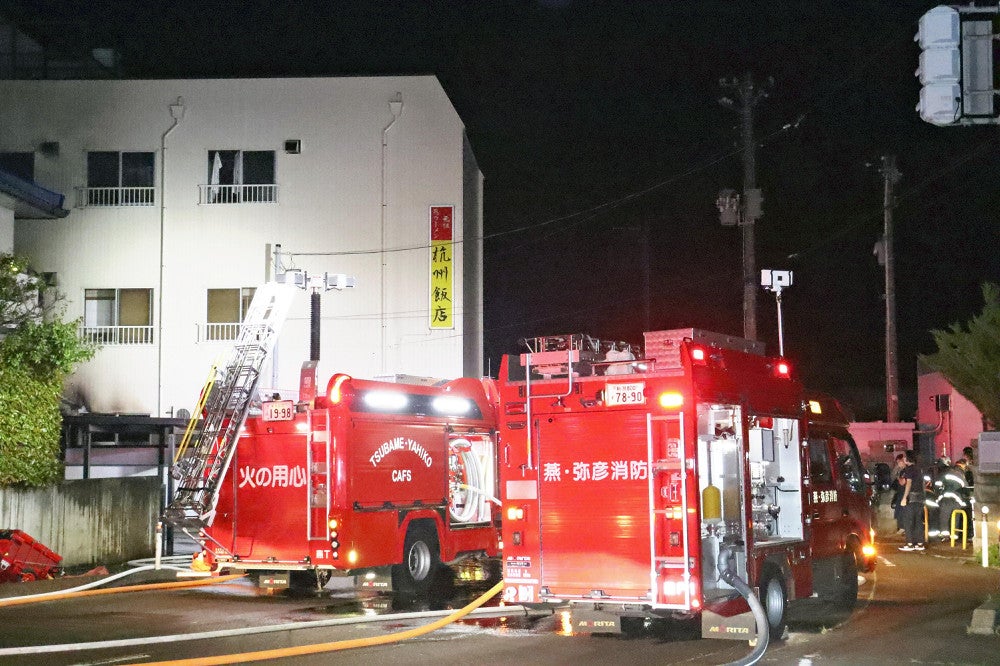 杭州飯店に駆けつけて消火活動にあたる消防車（１９日午後７時５１分、新潟県燕市燕で）＝徳井観撮影