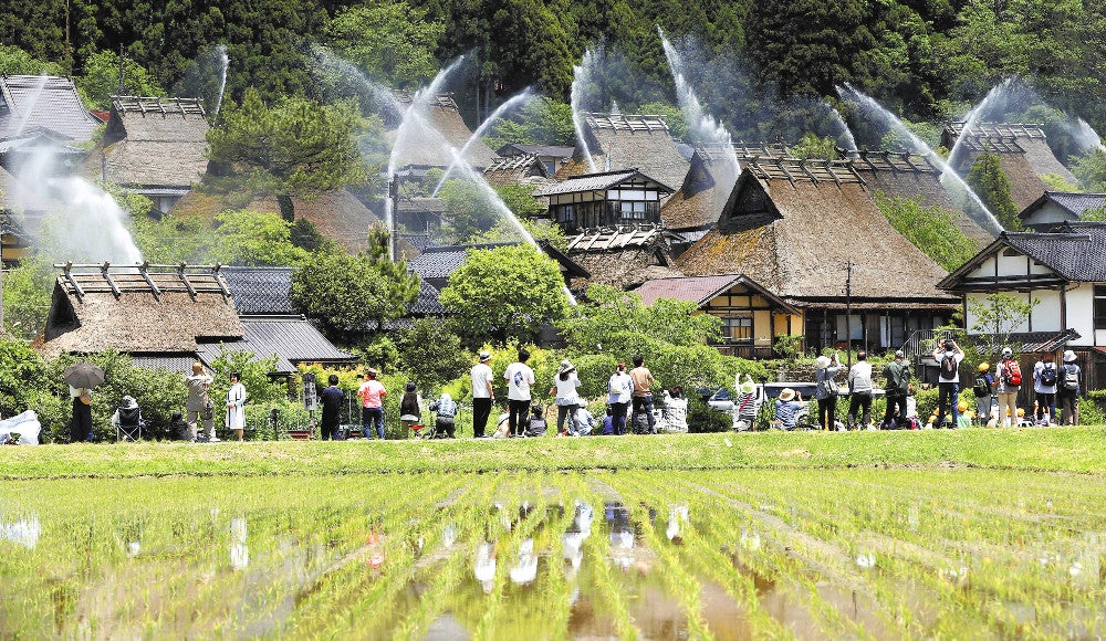 観光客らが見守る中、かやぶきの里で行われた放水訓練（２０日、京都府南丹市で）＝川崎公太撮影