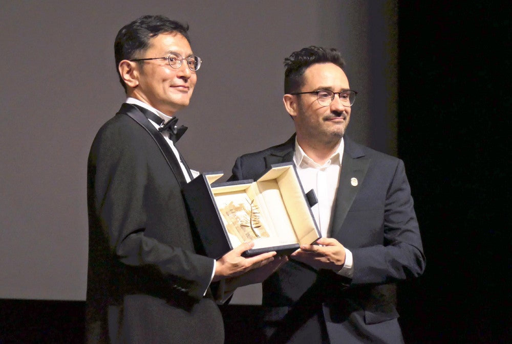 スタジオジブリを代表して「名誉パルムドール」のトロフィーを受け取った宮崎吾朗監督（左）（２０日、フランス・カンヌで）＝松田拓也撮影