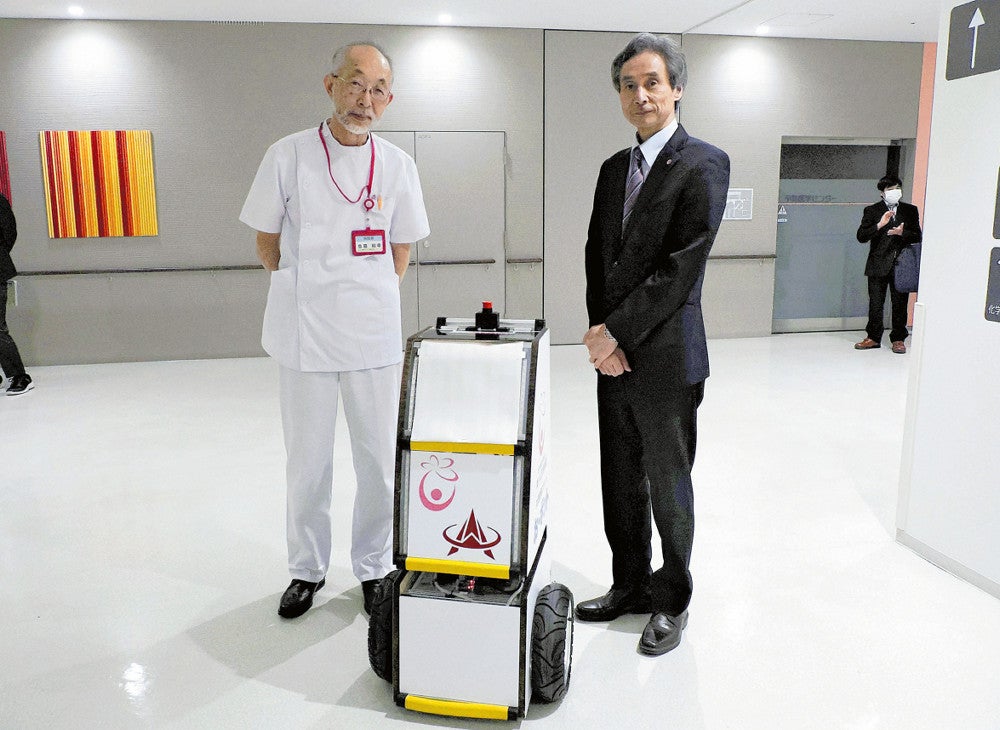 完成した検体搬送ロボットの運用開始を見守る島田病院長（左）と堀校長（小山市神鳥谷の新小山市民病院で）