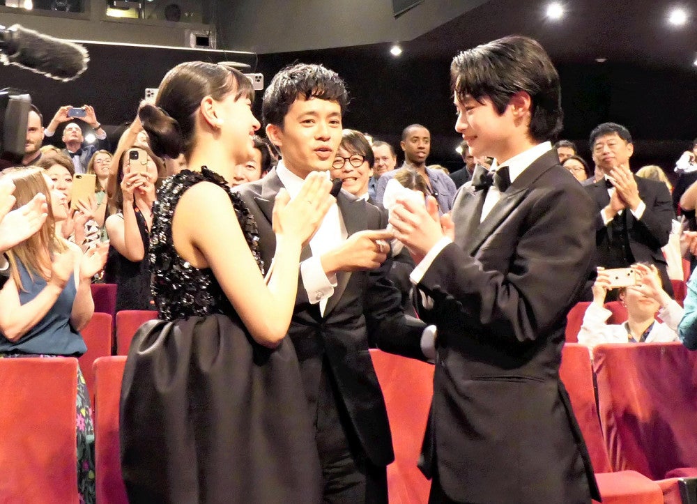 上映後、場内の大きな拍手に感極まる越山敬達さん（右）と池松壮亮さん（中央）、中西希亜良さん（１９日、フランス・カンヌで）＝松田拓也撮影
