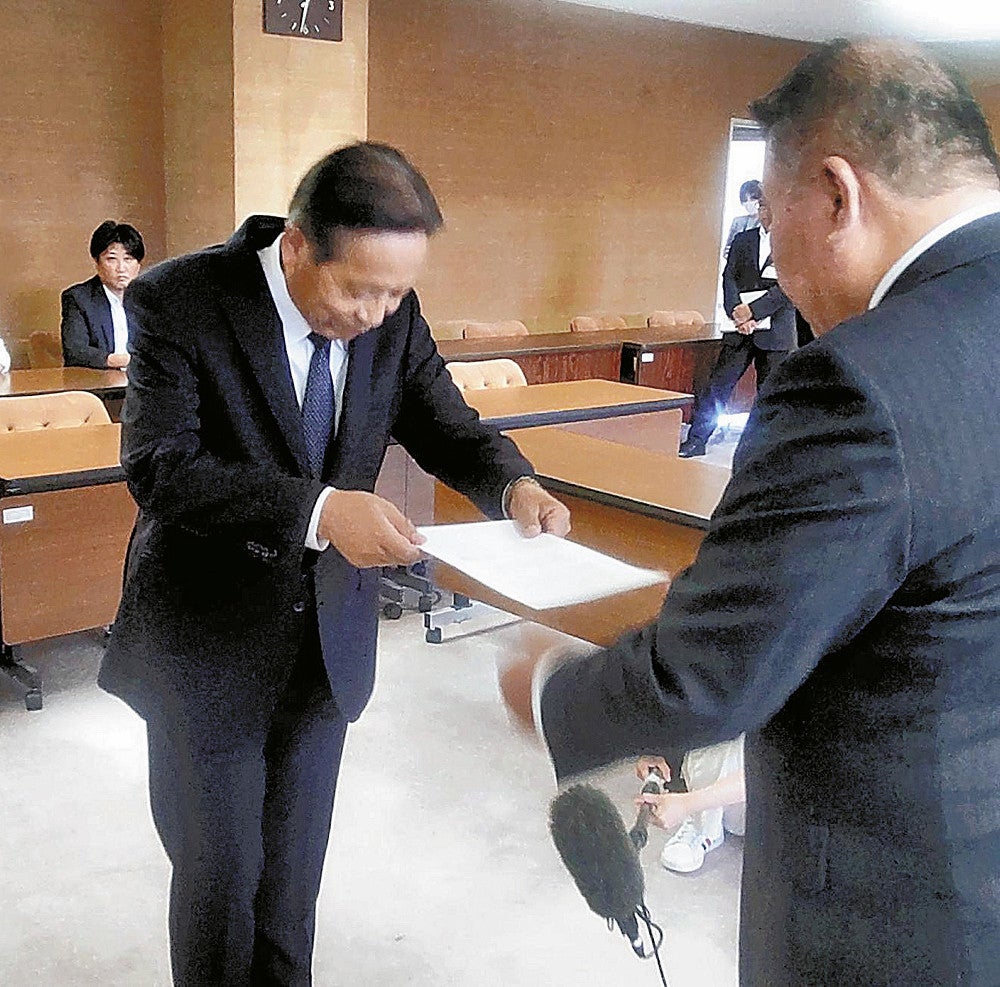 花牟礼薫議長から申し入れ書を受け取る中西市長（左）