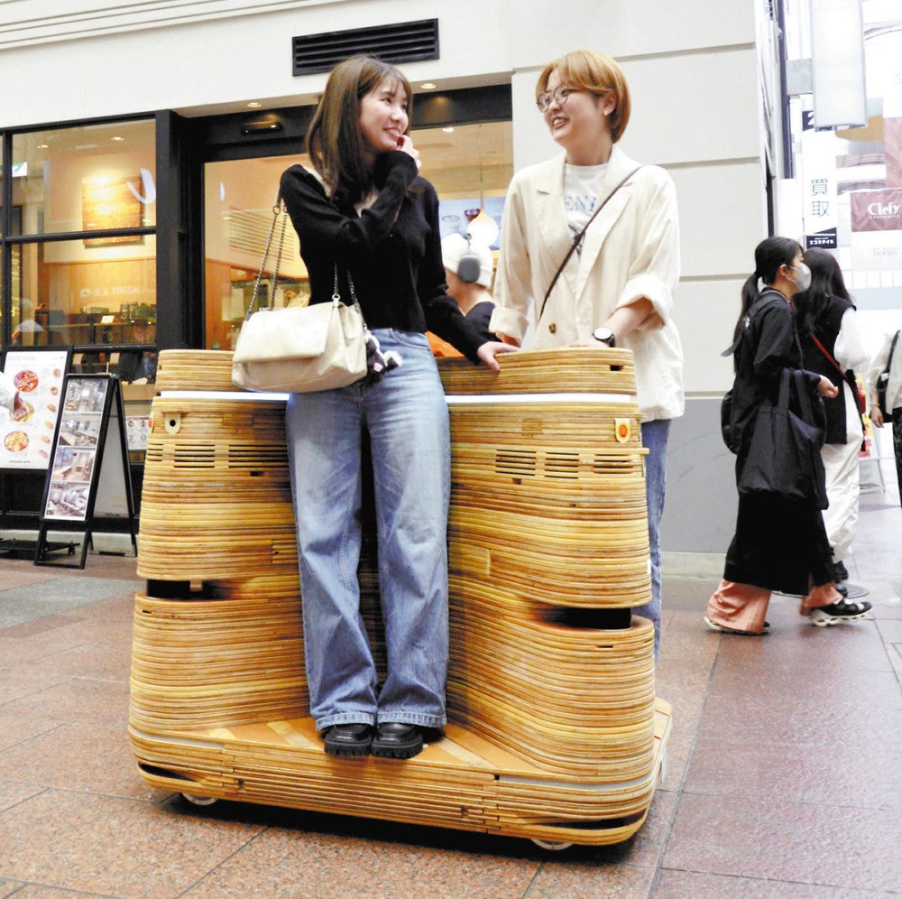 ゲキダンイイノが開発した低速モビリティーに試乗する買い物客ら（２２日、神戸市中央区で）