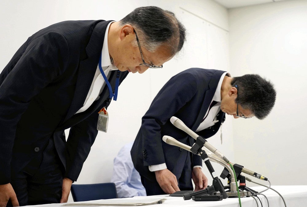 謝罪する村上教職員人事部長（左）ら（２１日、横浜市役所で）