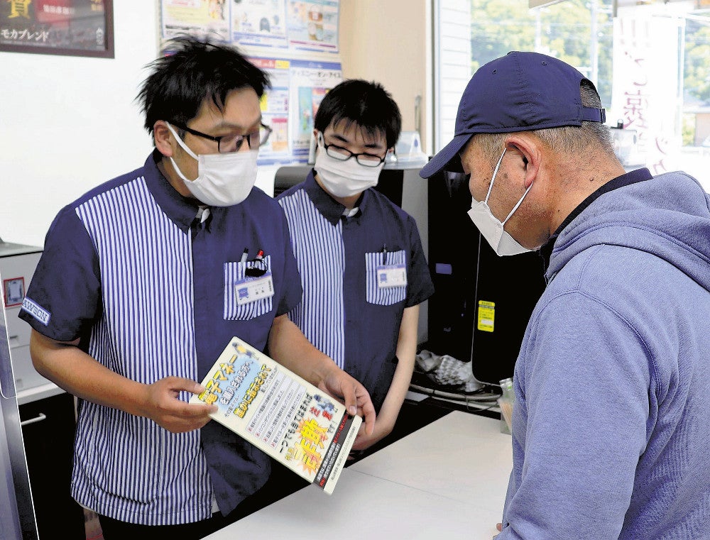 チェック表を見せながら詐欺への注意を促す店員ら（真庭市のローソン中国勝山店で）