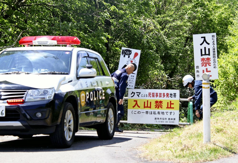 入山禁止地区付近で警戒にあたる警官ら（２１日、秋田県鹿角市で）