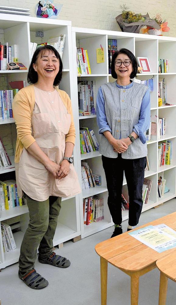 オーナーに貸し出した本棚の前で「本を通して、いろいろな人が心を寄せ合う場にしていきたい」と話す峠さん（左）と松浦さん（松江市で）