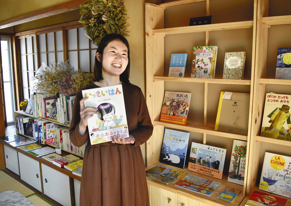 「本屋くるり」でおすすめの本を手にする藤野さん