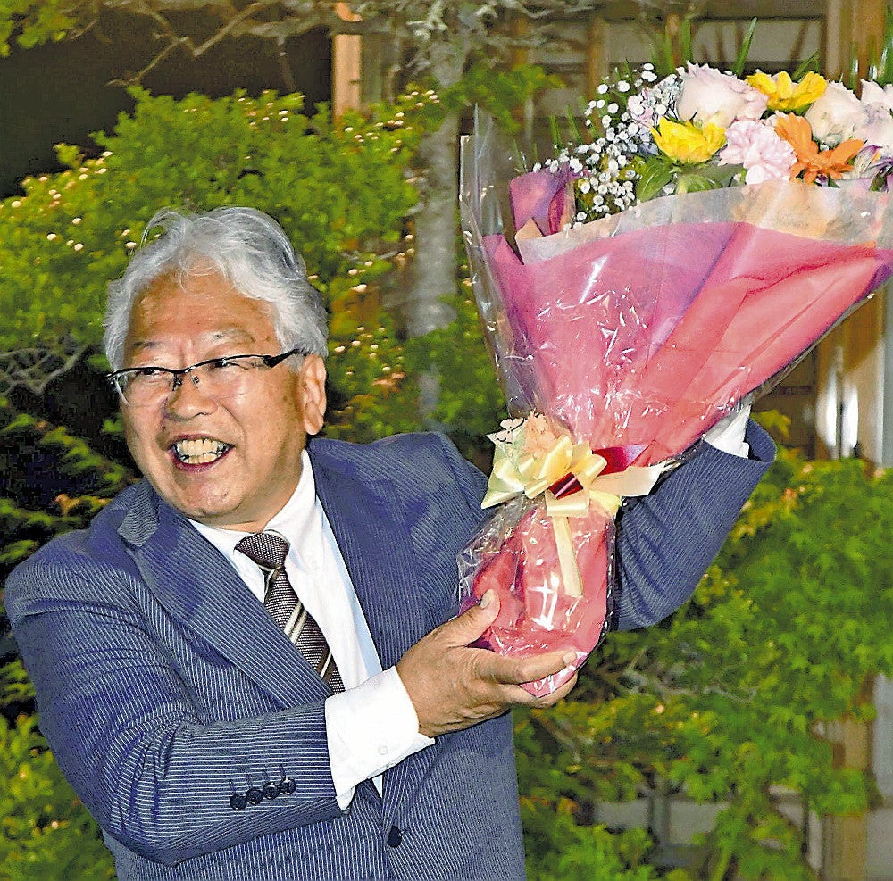 ４選を決め、笑顔で花束を受け取る舩木氏（２６日、小菅村で）