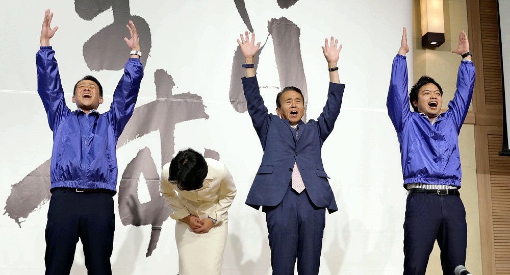 当選確実の一報を受け、万歳する鈴木康友氏（右から２人目）（２６日午後１１時２１分、静岡市葵区で）