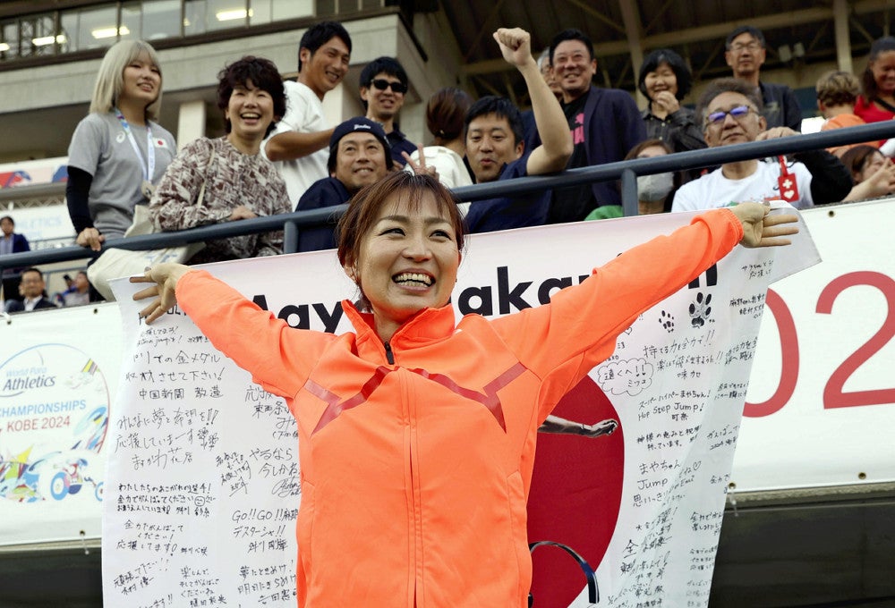 女子走り幅跳びで銅メダルを獲得し、日の丸を広げる中西麻耶（２０日）＝古厩正樹撮影