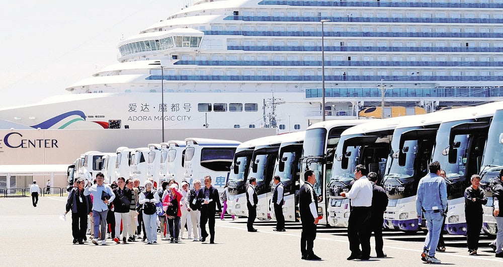 クルーズ船から下船し、観光バスに向かう訪日外国人客ら（１６日午後、福岡市博多区の博多港中央ふ頭クルーズセンター前で）＝中山浩次撮影