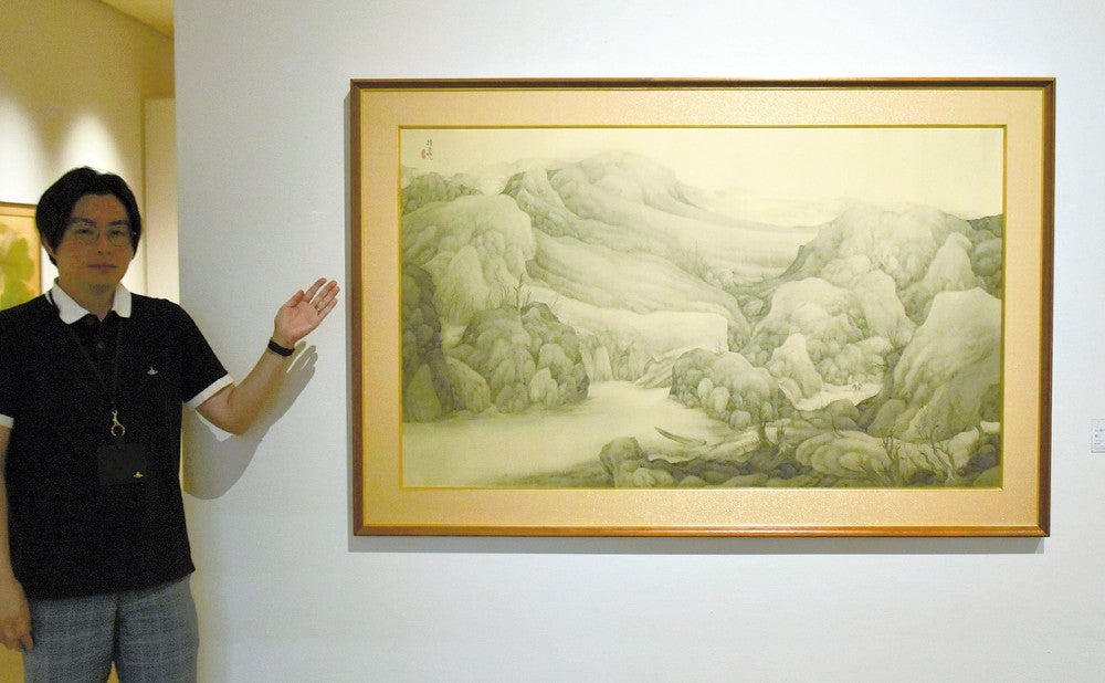 細い線で理想郷を描いた魯牛の南画「寒江」を説明する手呂内さん
