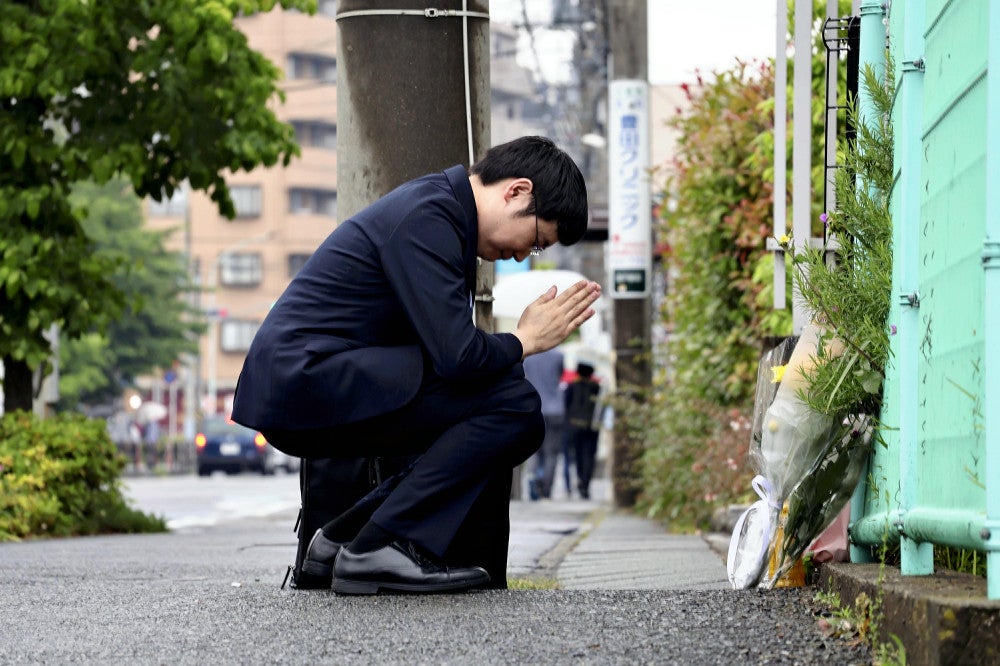 現場で献花し、手を合わせる男性（２８日、川崎市多摩区で）＝北川穂高撮影