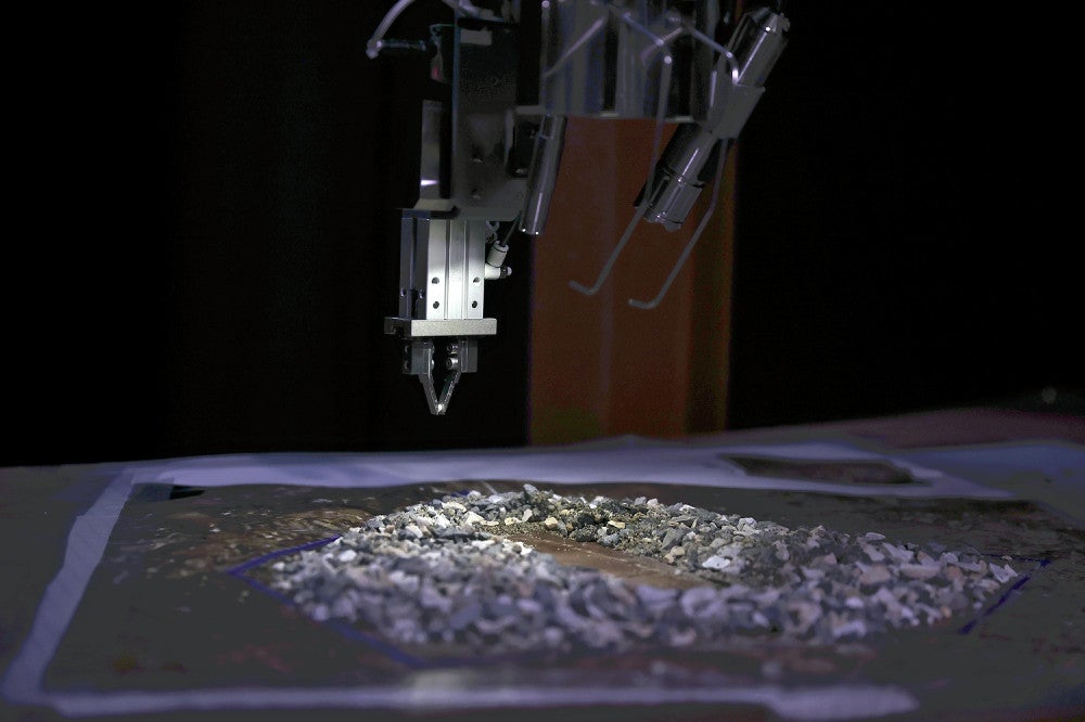 核燃料デブリを模した小石（手前）をつかむ作業が報道陣に公開された釣りざお式装置＝代表撮影（神戸市の三菱重工業神戸造船所で）