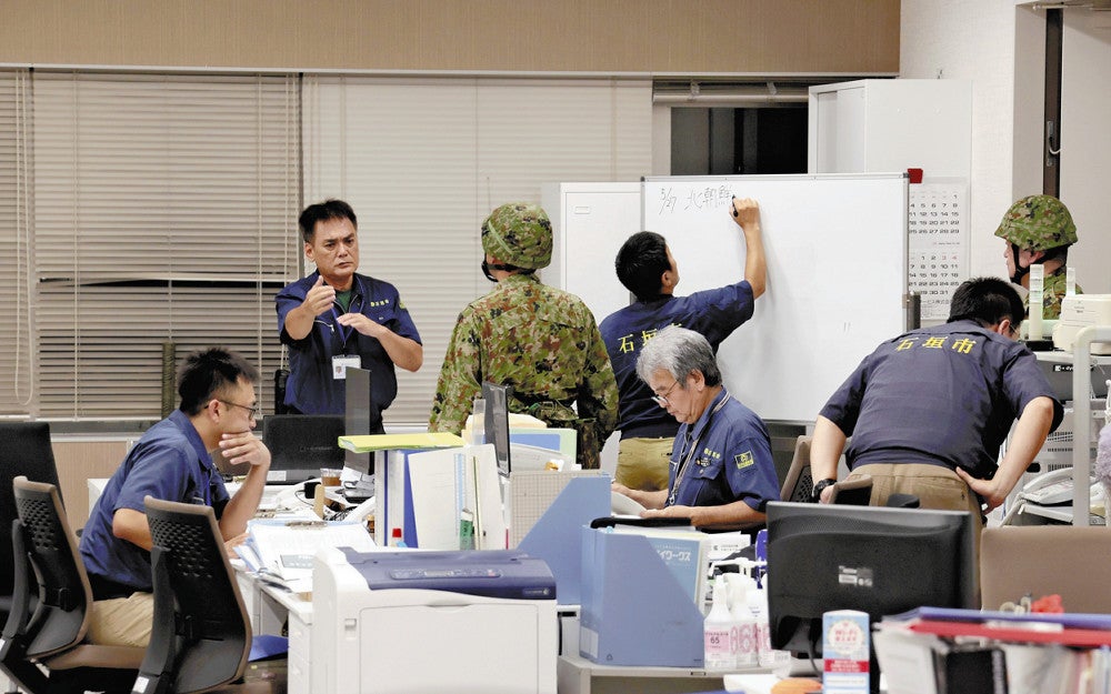 北朝鮮から発射された弾道ミサイルの可能性があるものについて、市役所で情報収集にあたる防災危機管理課の職員ら（２７日午後１１時２１分、沖縄県石垣市で）＝長野浩一撮影