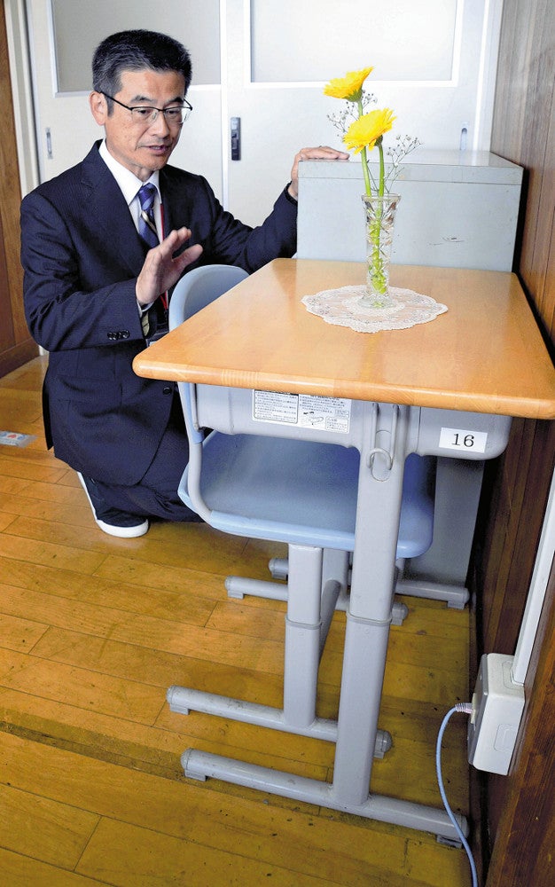 女児の机と椅子を見つめる黒田校長（７日、長崎県佐世保市の大久保小で）＝坂口祐治撮影