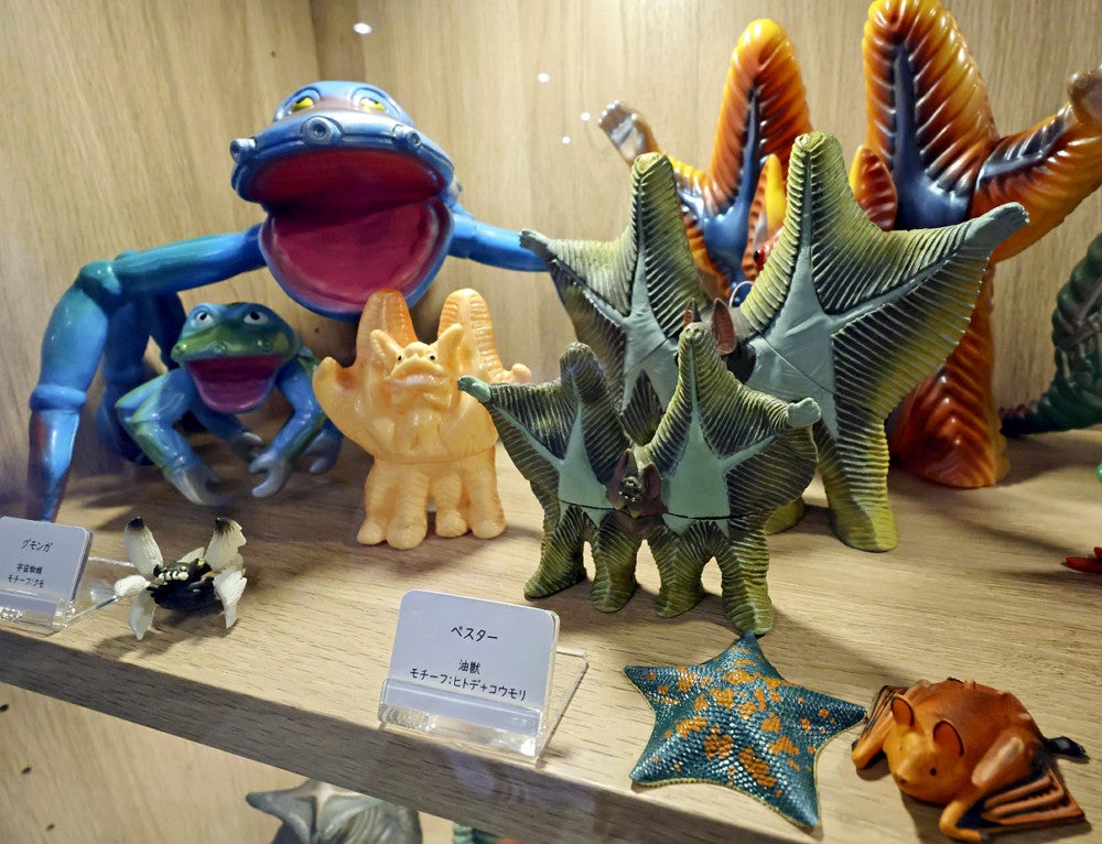 モチーフとなったヒトデのフィギュア（手前）と比較し展示された怪獣人形（１０日、福岡市東区のマリンワールド海の中道で）＝佐伯文人撮影