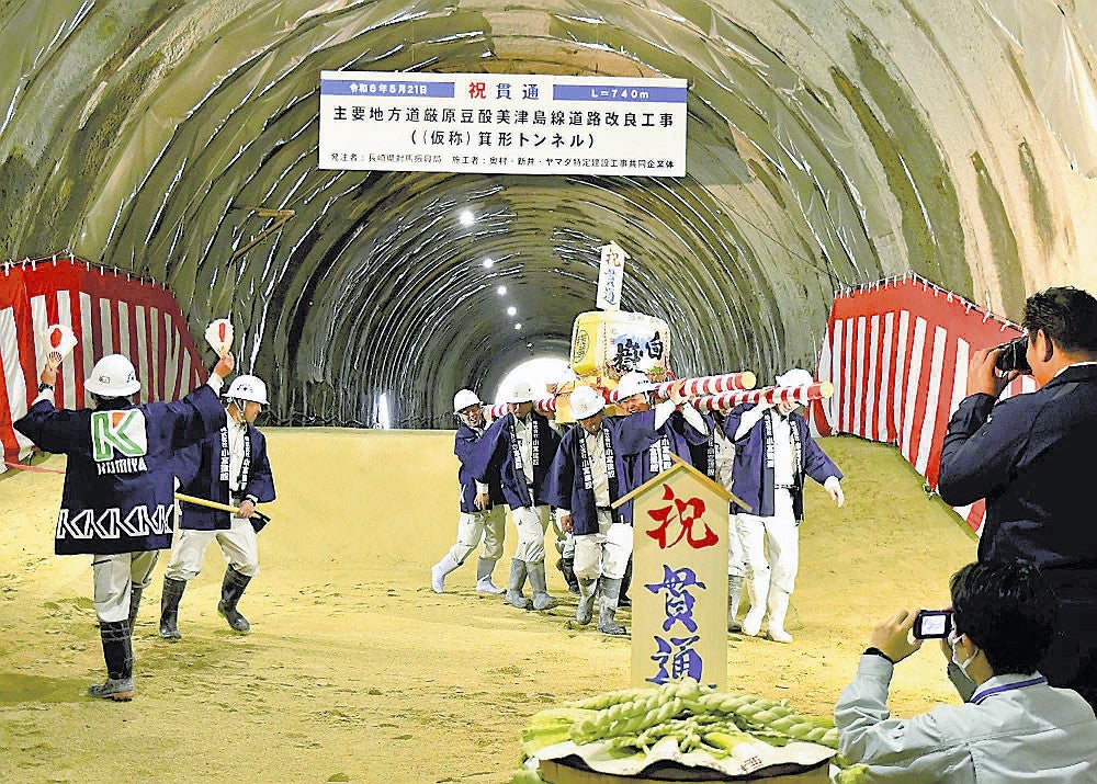 貫通を祝い、たるみこしを入場させる関係者ら