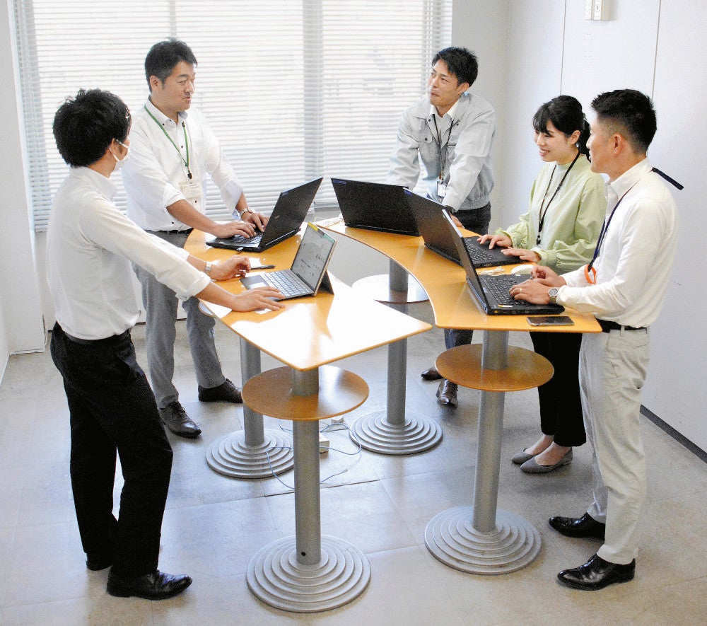 立ったまま打ち合わせをする職員