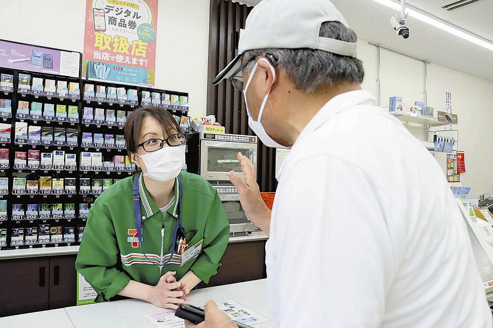 高齢者役（右）に「詐欺かもしれない」と声をかける店員（和歌山市で）
