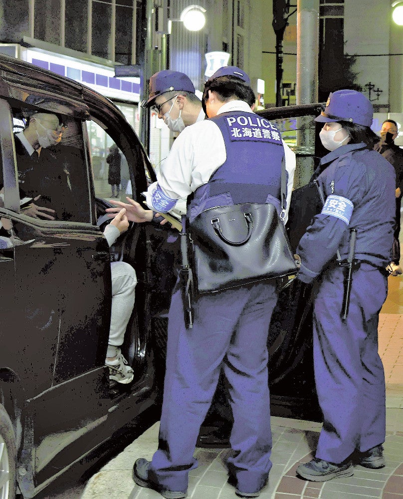 違法駐車に注意を促す警察官（５月３０日午後８時過ぎ、札幌市中央区で）