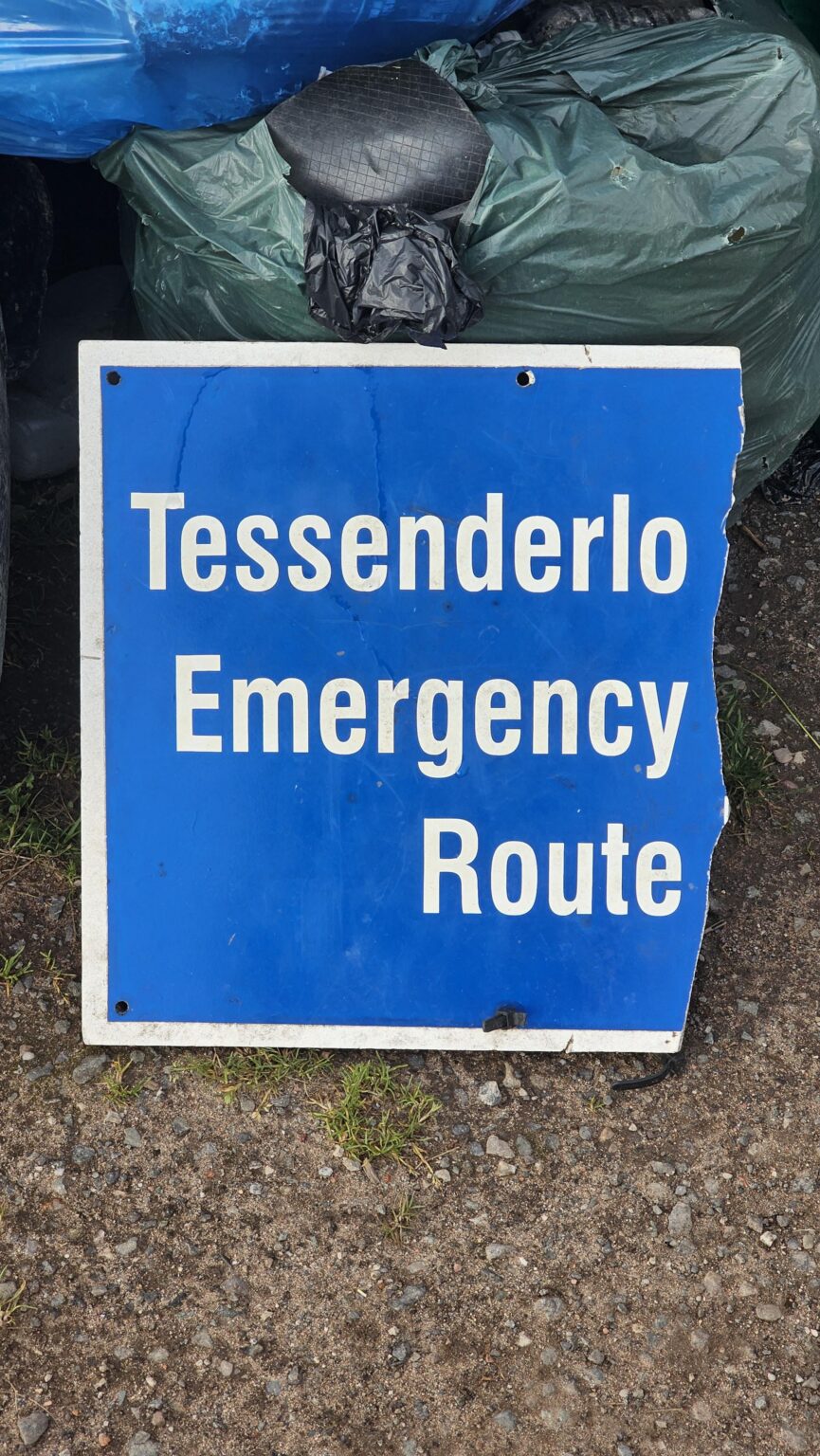 この道路標識の残りの部分に何が書いてあるか知っている人はいますか？ベルギーの町、イギリスで見つかった標識