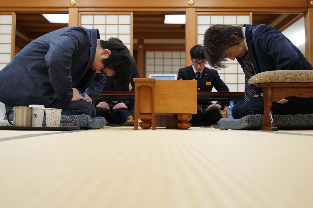 対局開始の合図で一礼する久保利明九段（右）と山崎隆之八段＝若杉和希撮影