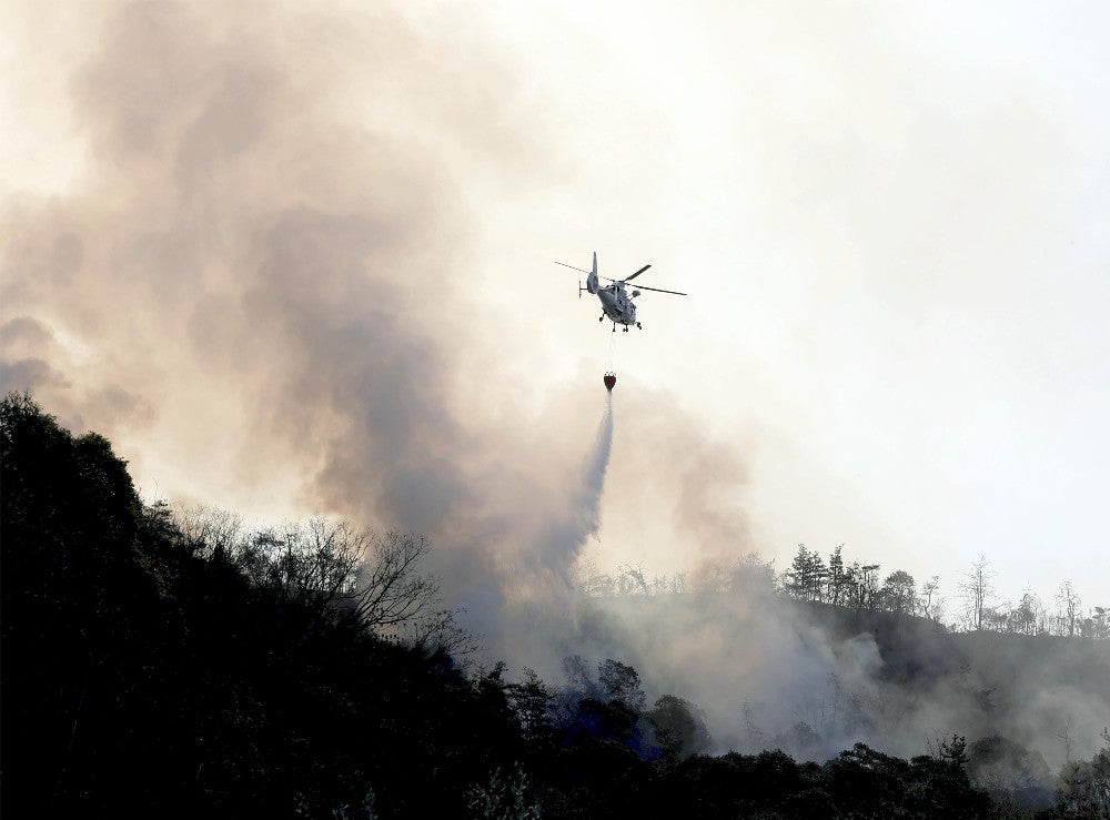 現場上空で消火活動を続けるヘリコプター（１月１４日午前９時５３分、江田島市で）＝東直哉撮影