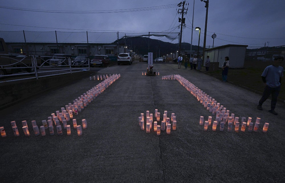 復興への思いなどが記された紙灯籠が「１・１」の形に並べられ、夕闇に浮かび上がった（１日夜、石川県輪島市で）＝帖地洸平撮影