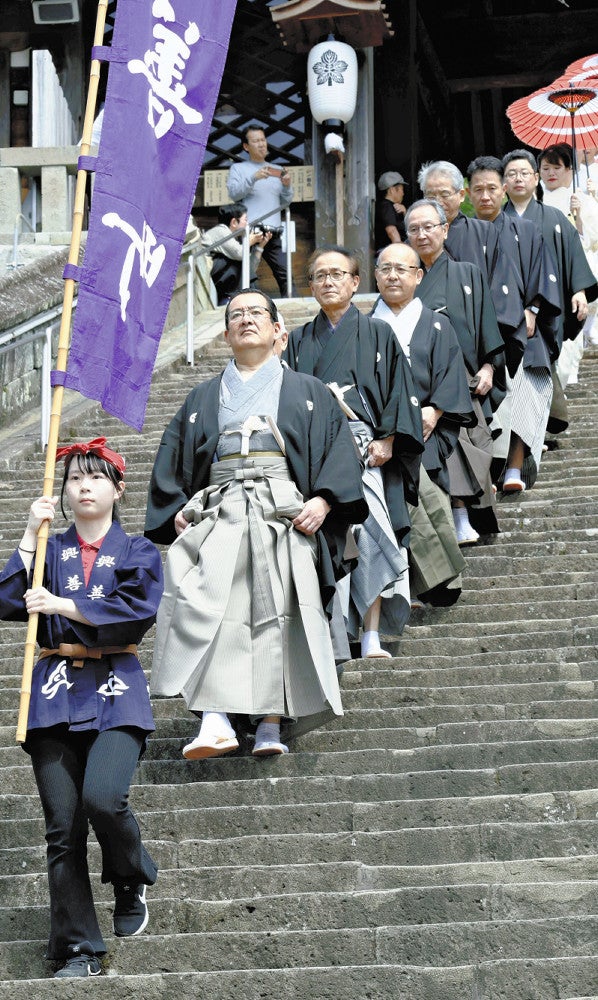 諏訪神社の長坂を下る出演者ら