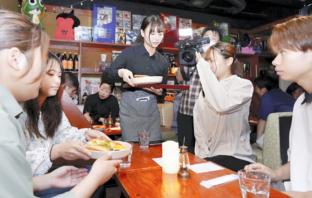 接客をする学生（中央）