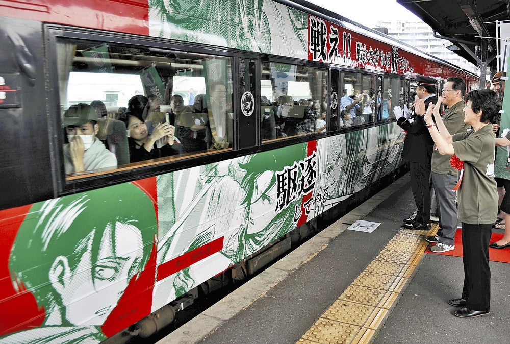 発車する「進撃の巨人」のラッピング列車