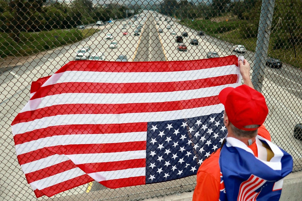 １日、米カリフォルニア州で上下逆さまの星条旗を掲げるトランプ前大統領の支持者＝ロイター