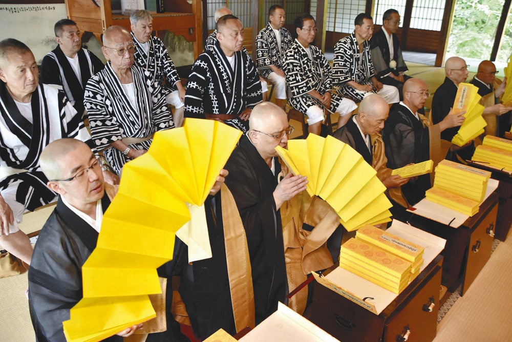 経典をめくりながら読経する僧侶ら