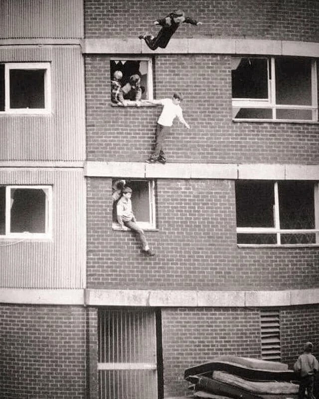 使い古したマットレスの上で跳ね回る子供たち。イギリス、1980 年代。