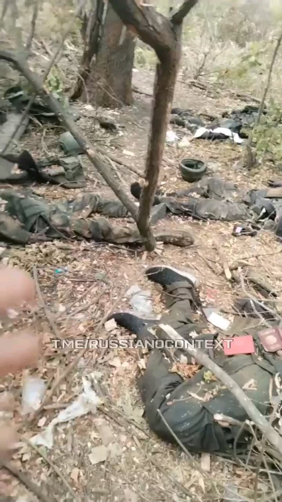 ロシア軍兵士らが、戦友の死体が散乱する着陸地点を視察している。