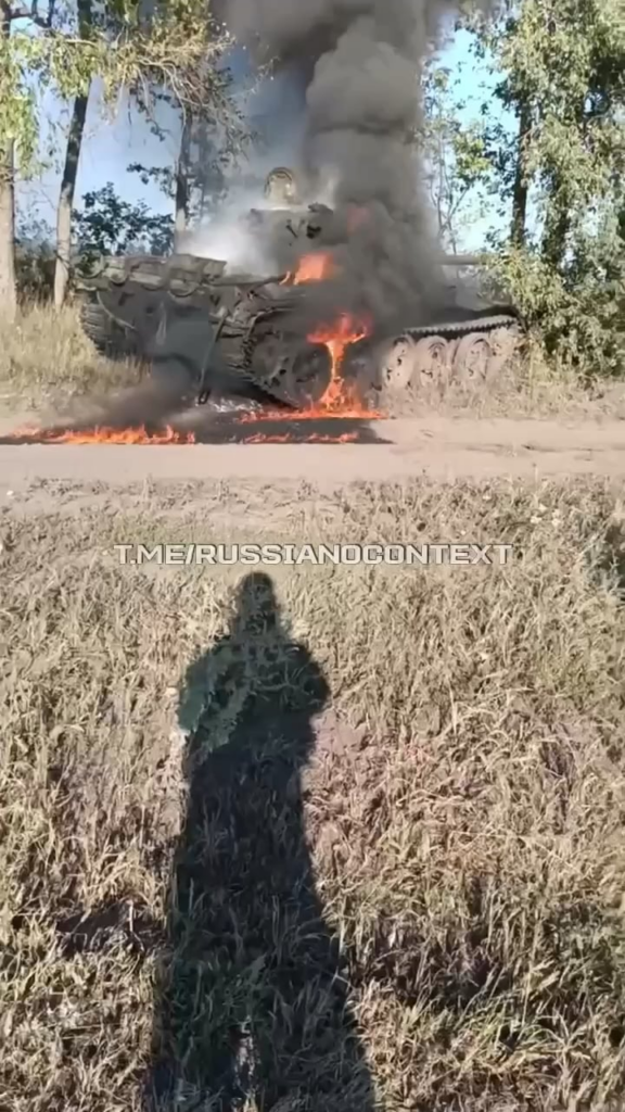 ウクライナ軍によって破壊され、燃え上がる戦車を撮影するロシア兵士。日付も場所も不明。