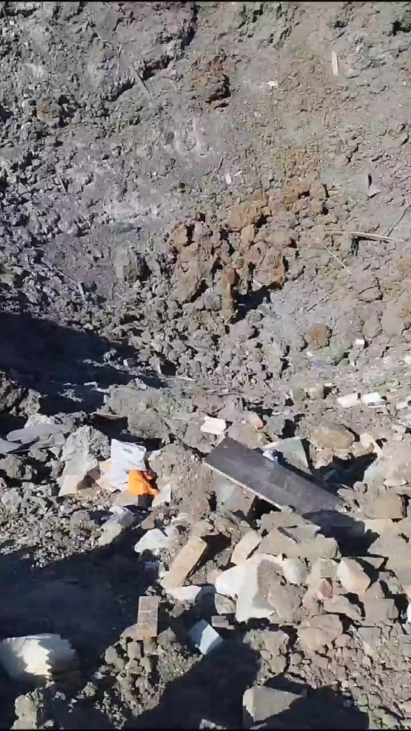 空爆後に残されたクレーターを調べるウクライナ人。場所不明