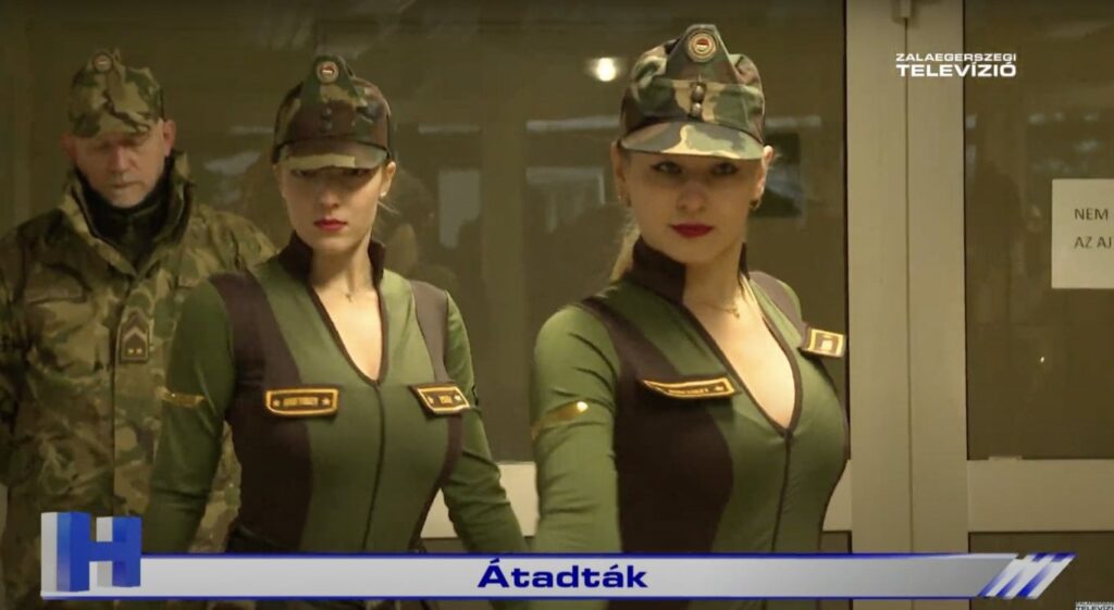 イーゲルセクの人材募集オフィスは、エレベーターの前でハイヒールを履いてポーズをとる軍服を着た女性ダンサーによって開設された