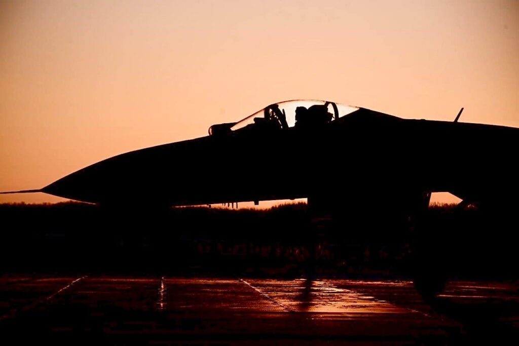 ウクライナ空軍のスホーイ Su-27「フランカー」多用途戦闘機 - 朝日を背景に任務に向かうシルエット。