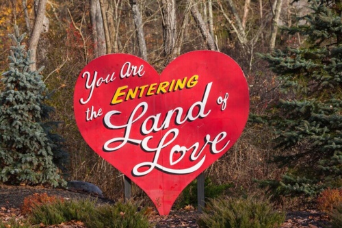 「愛の国」と書かれたハート形の看板が、パラダイス・ストリーム・リゾートで旅行者たちを出迎える。（Photograph by mauritius images GmbH, Alamy）